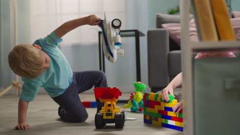 blond toddler plays with airplane and transportation toys