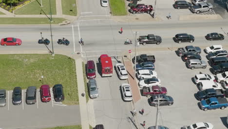 aerial view of red ambulance vehicle driving and turning on the intersection during the dogwood festival in siloam springs, arkansas