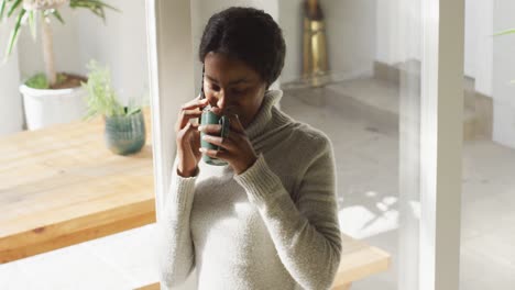 Video-Einer-Afroamerikanischen-Frau,-Die-Zu-Hause-Kaffee-Trinkt