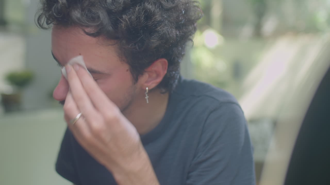 Man Removing Face Mask with Tissue Paper