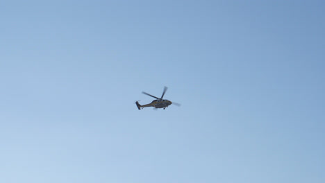 a chopper flying on a sunny day with blue sky background