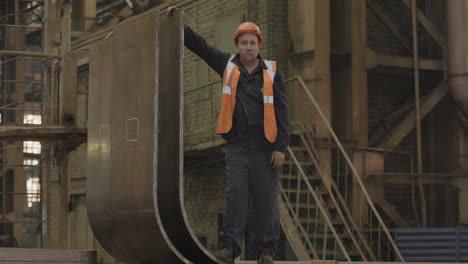 factory worker holding a large metal plate