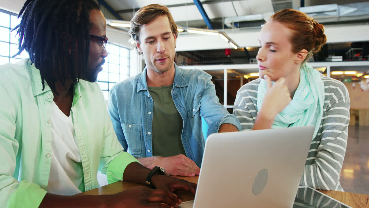Colleagues interacting with each other over laptop
