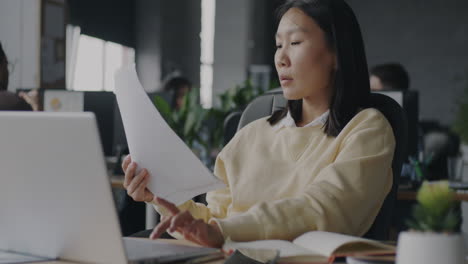 woman reading documents in modern office