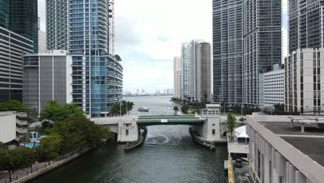 aerial view of a mega yacht approaching the miami river before the brickell avenue bridge and beautiful downtown miami, florida, usa