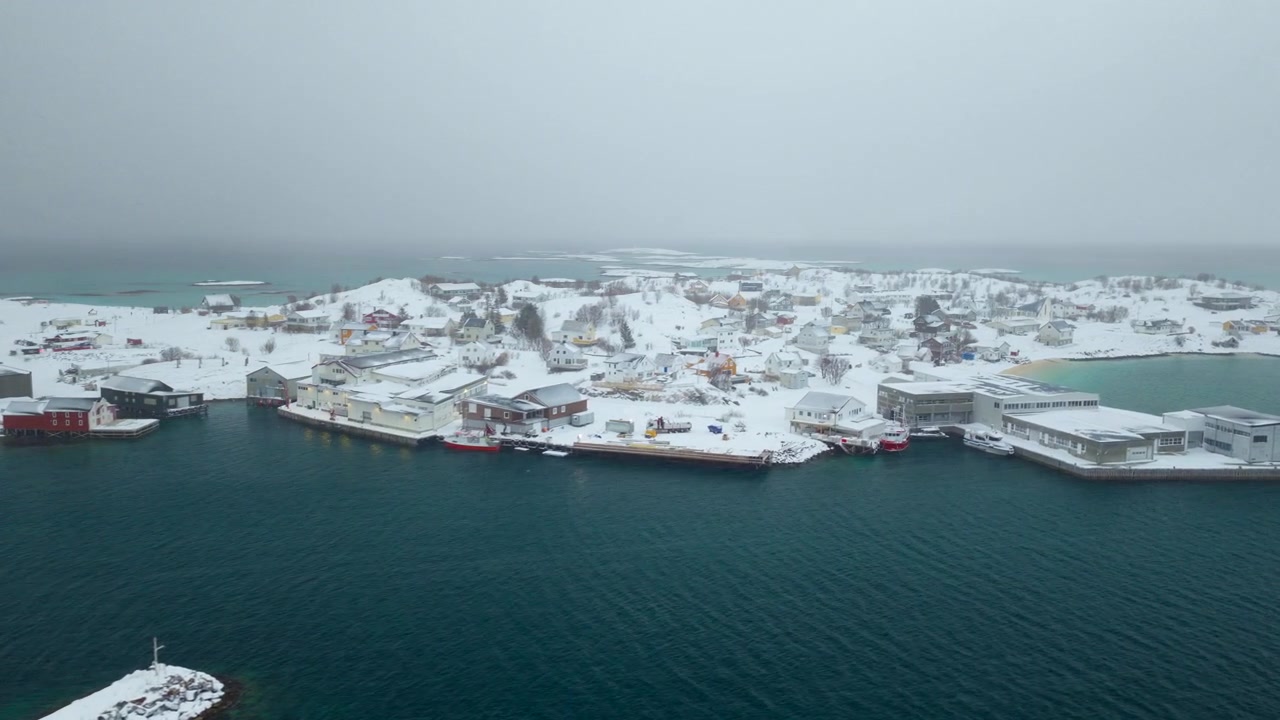 Norveç'in Sommaroy kıyı köyünün limanında balıkçı tekneleri ve karla kaplı binalar. Hava drone görünümü, metin alanı.