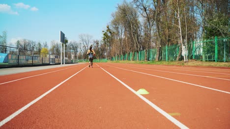 young woman go in for sport run at the stadium track in the morning. summer outdoors training