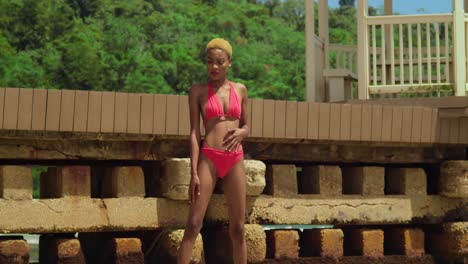 disfrutando del calor del caribe, una chica negra en un bikini rojo disfruta de la tranquilidad de una playa de arena blanca