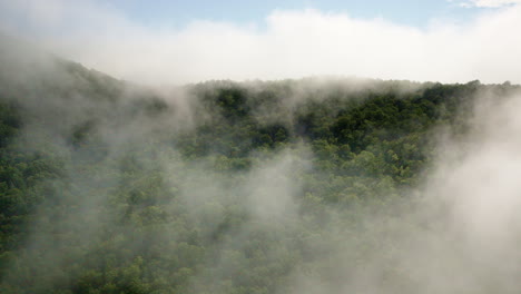 aerial drone pushes gently into a fog-laden mountain range