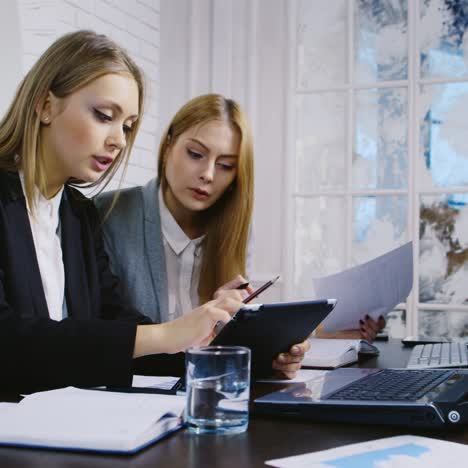 Employees-Compare-a-Project-on-Paper-And-a-Tablet