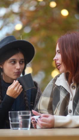 two women enjoying coffee outdoors