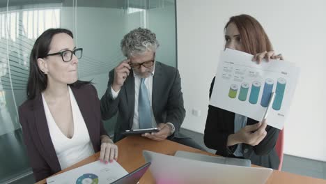 caucasian pretty businesswoman showing statistics to colleagues