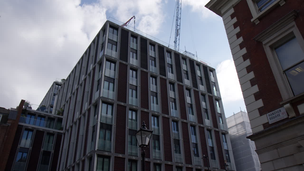 Hotel Building With Construction Tower Crane On Top In London, England. Low Angle Shot