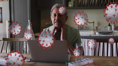 animation of covid 19 cells over sick senior man touching his face with laptop at home