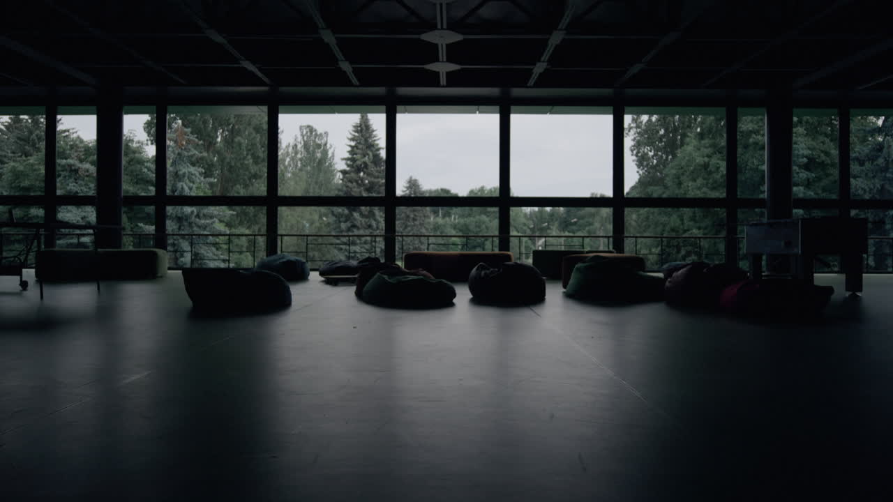Modern empty hall interior with bag chairs sofa at panorama window background.