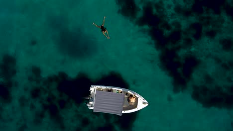 Top-View-of-Couple-Enjoying-Turquoise-Tropical-Waters-with-a-Boat