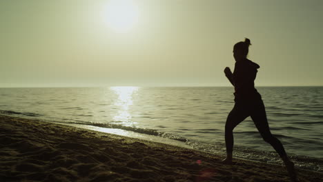 Mujer-Corredora-De-Vista-Posterior-Al-Atardecer-De-Verano.-Chica-Corriendo-A-Orillas-Del-Mar-En-Ropa-Deportiva.