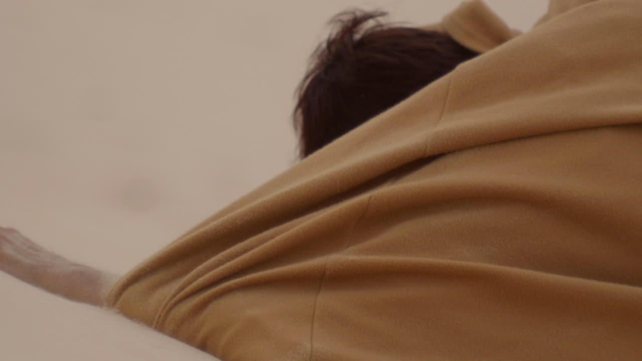 отчаянный азиатский мужчина в халате пытается прогуляться по рукам по песчаным дюнам в поисках помощи и воды