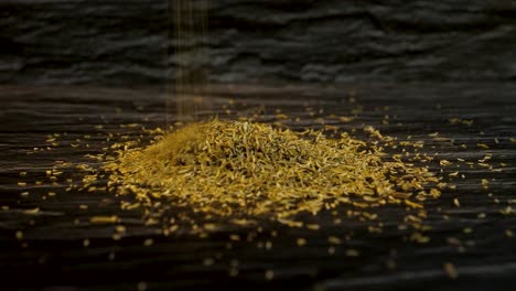 aromatic thyme herb spice falling in a small pile with a dark textured background