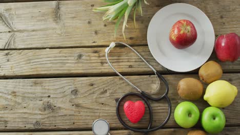 video de estetoscopio, frutas y verduras frescas con espacio de copia sobre fondo de madera