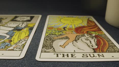 una foto de cerca de las cartas del tarot colocadas para la lectura en la mesa con velas 6