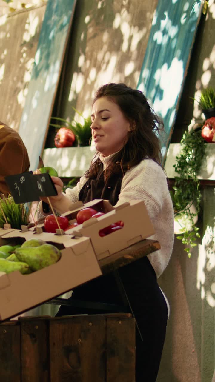 Vídeo vertical: joven vendedor ofreciendo muestras gratuitas de manzana a sus clientes