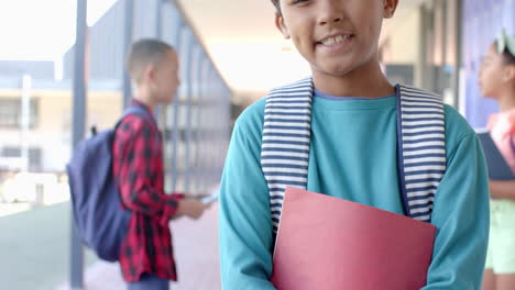 Biracial-boy-smiles-at-school,-with-copy-space