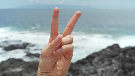 Peace-sign-in-front-of-Tenerife-coastline,-POV-view