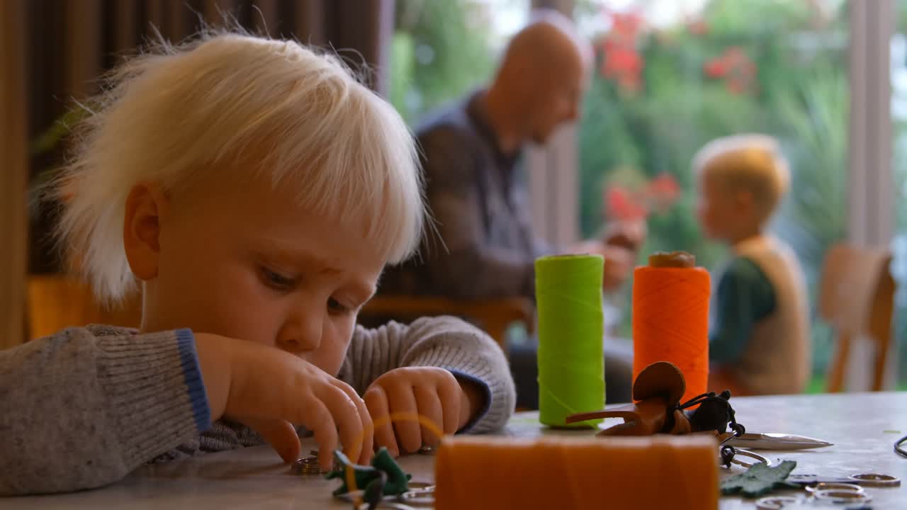 Girl playing with keychain on a table at home 4k