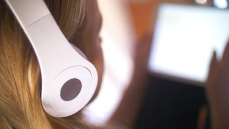 Woman-in-earphones-working-with-touch-pad