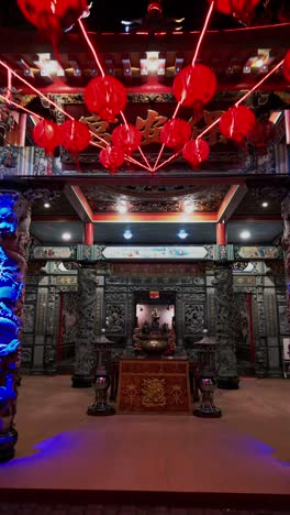 this vertical video showcases a buddhist temple entrance beautifully lit with glowing lanterns and artistic carvings blending traditional architecture and spiritual symbolism in a calming night scene