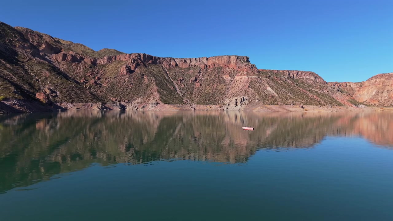 Những vách đá hẻm núi lởm chởm phản chiếu trong hồ chứa Valle Grande bên trong Hẻm núi Atuel gần San Rafael, Mendoza, Argentina, phong cảnh Andes bán khô hạn được hình thành bởi sự xói mòn của sông, cảnh quay trượt ngang sang trái.