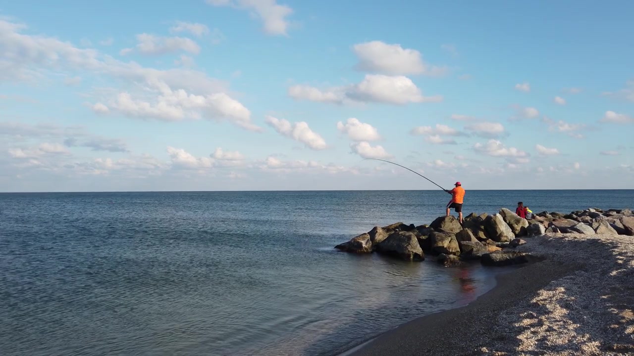 Pesca sulla battigia. Riprese in estate