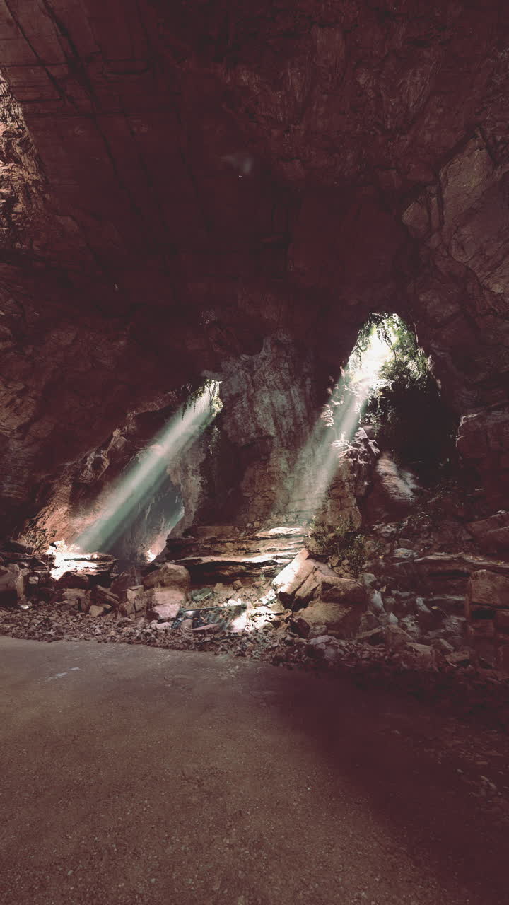 rayos de sol brillando a través de la entrada de una cueva