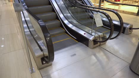 shoppers go up the escalator in the mall. shopper feet on escalator in shopping center. legs of people moving on an escalator lift in the mall