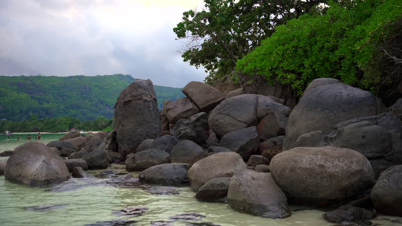 imágenes de las seychelles de la isla principal mahe filmadas en una playa con una cámara que filma rocas de granito, mar, playa y bosque con un movimiento suave