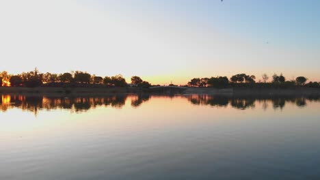 Flying-over-water-lake-at-sunset