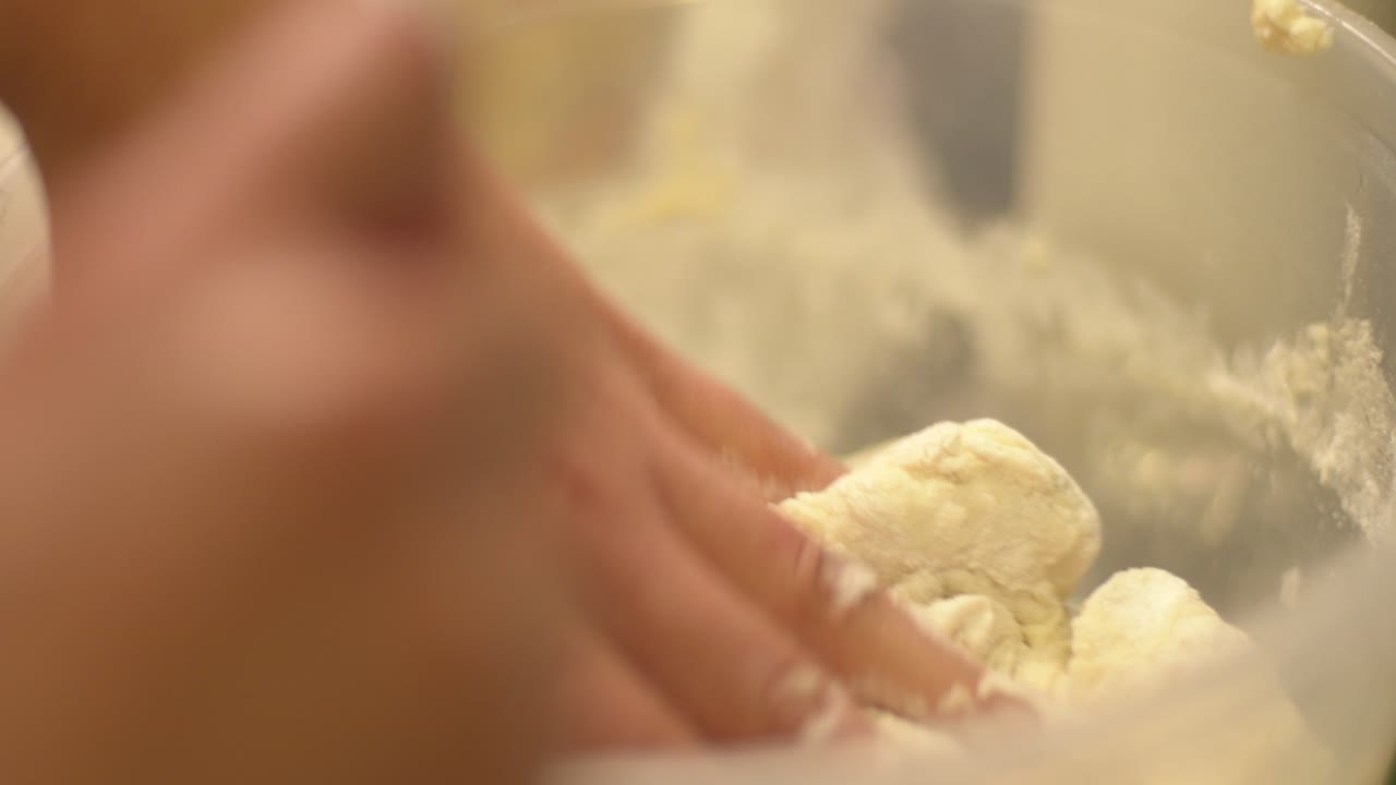 Kneading dough by hand in clear bowl