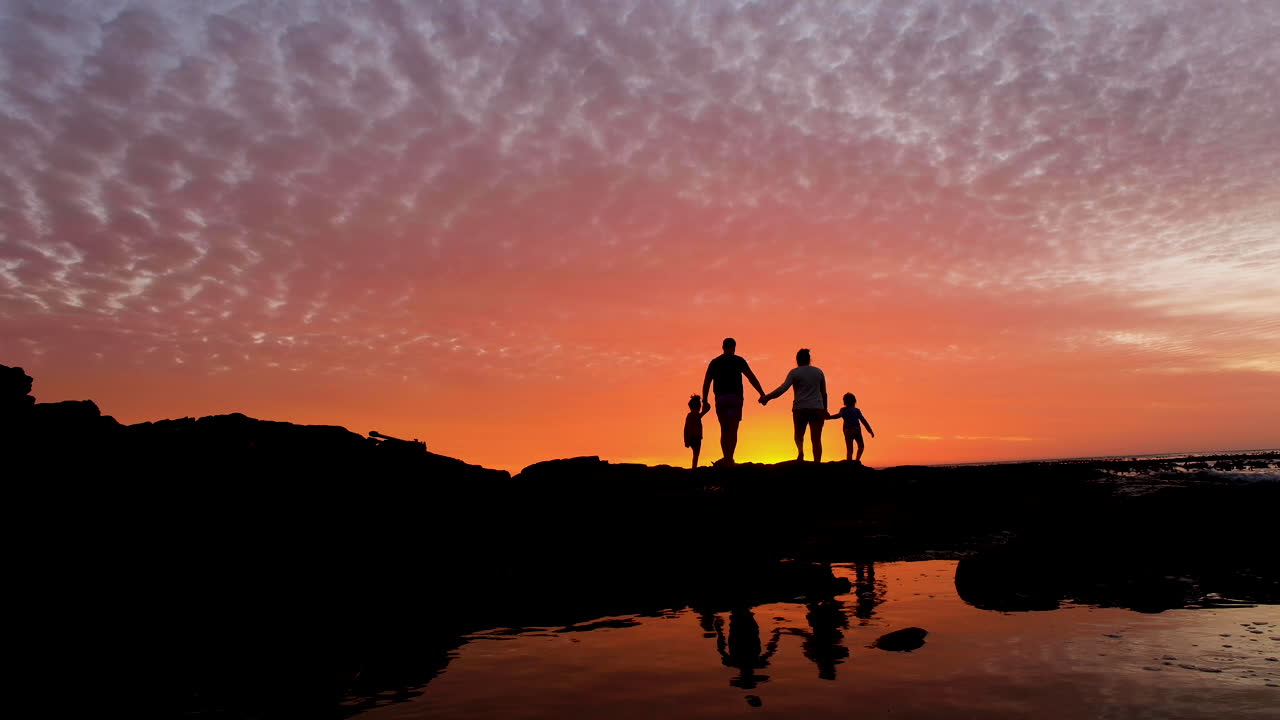 바위 해안선에 가족 화재 일몰을 즐길 수
