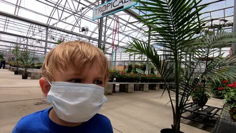 A-Boy-Wearing-Facemask-Walks-On-The-Plant-Nursery-In-Michigan