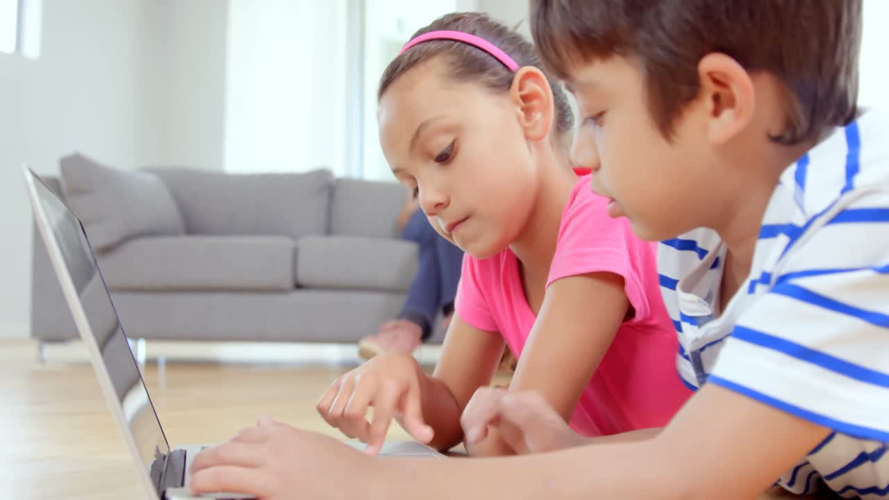niños enfocados escribiendo en una computadora portátil