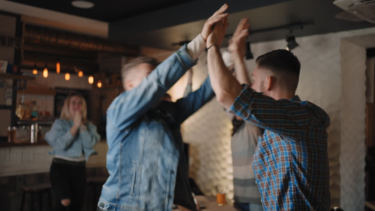 A group of men and women in a pub together cheer for their national team at the World Cup in football basketball hockey. Celebrate the goal scored the puck. Mark the scored penalty