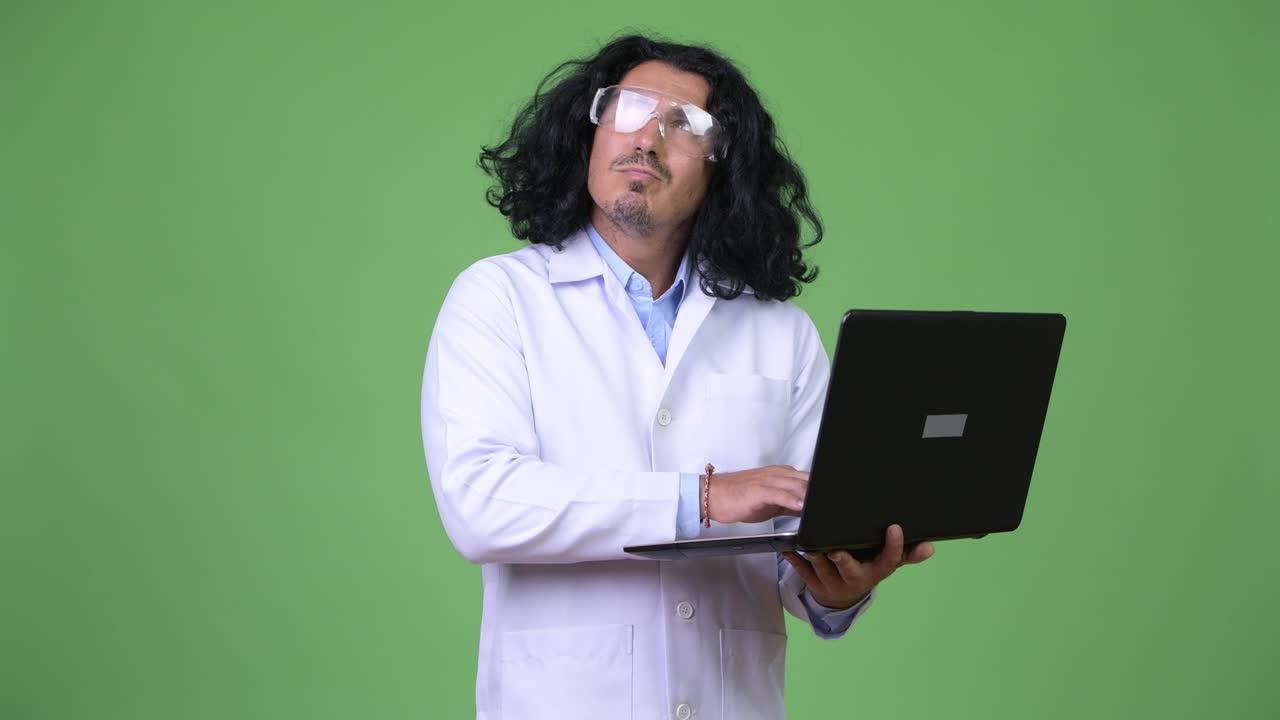 Handsome man scientist thinking while using laptop