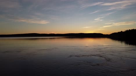 Picturesque-evening-dusk-blue-hour-aerial-over-calm-lake-in-Sweden