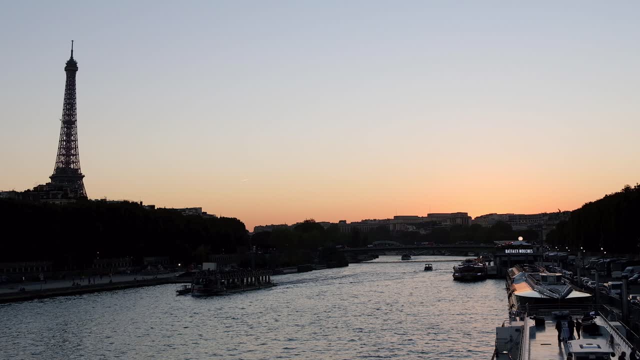 Distant view of the Eiffel Tower in the evening with buildings surrounding it and the Seine in Paris, France