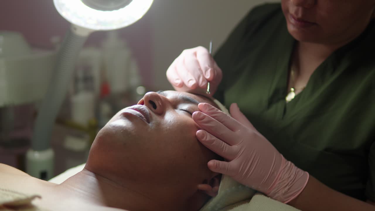 Client masculin latino-mexicain profitant d'une thérapie contre l'acné, de soins de la peau, d'un nettoyage en profondeur et d'une élimination des impuretés dans un centre de bien-être ou un spa, pour se détendre.