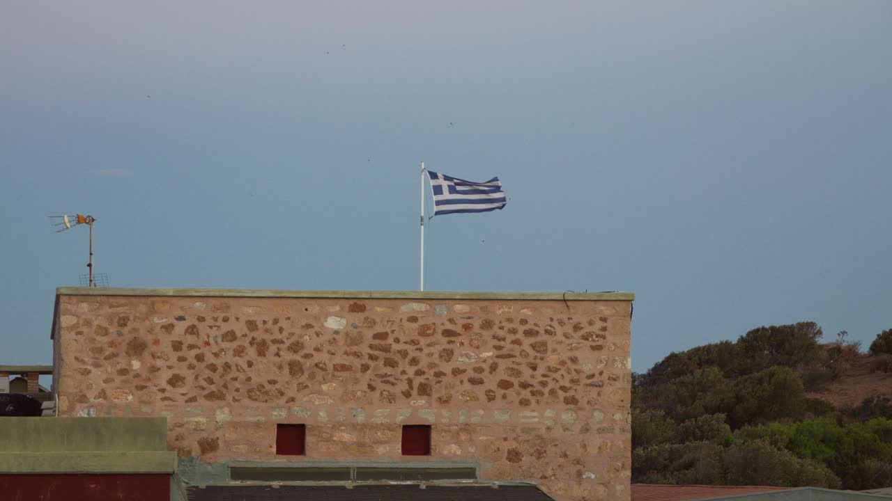 Greek Flag on a Stone Building overlooking a Hillside