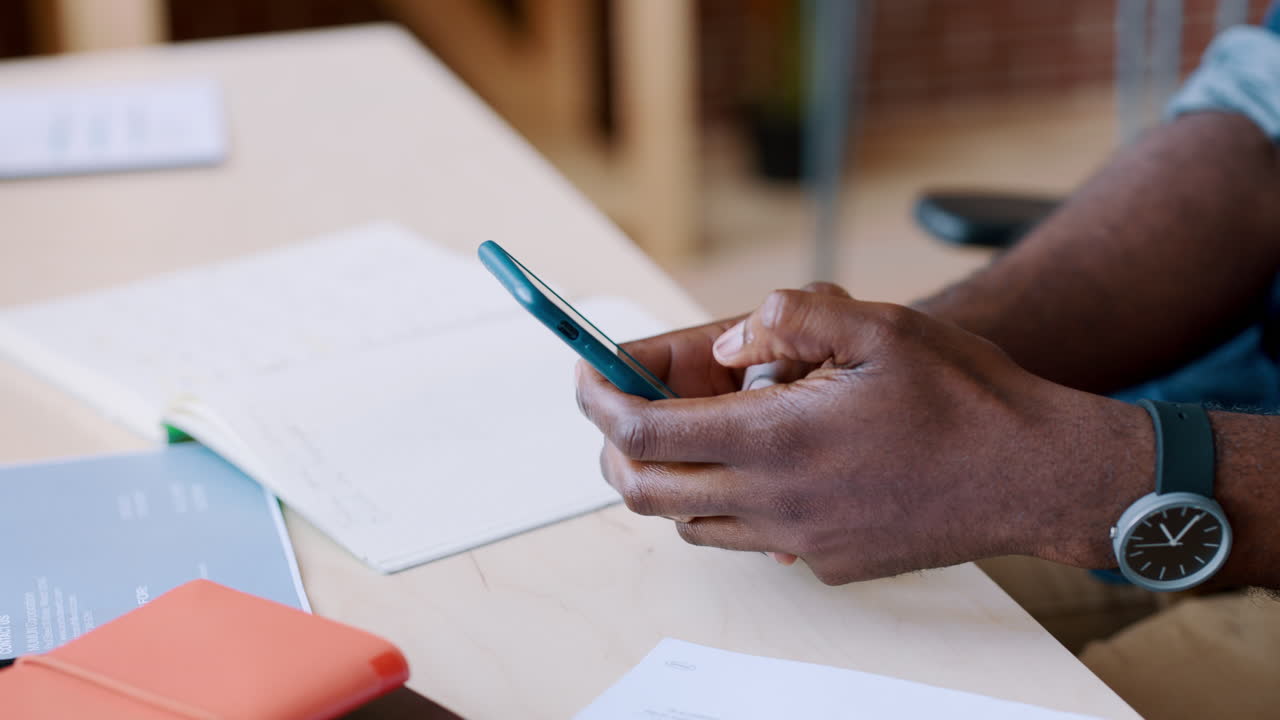 Person Using Smartphone at a Desk