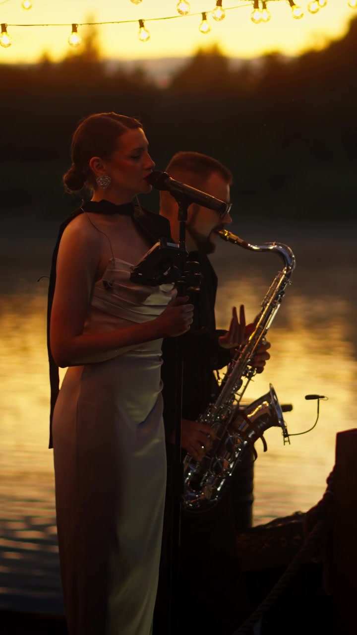 Cantante donna e sassofonista uomo che si esibiscono dal vivo al tramonto