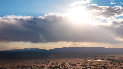 lapso de tiempo aéreo sobre la ciudad de california con el sol brillando a través de las nubes y los rayos del sol arrojando luz y sombra sobre la comunidad en el valle